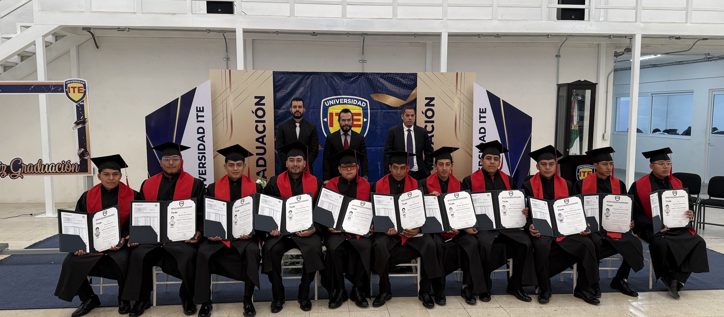 Grupo de egresados de Universidad ITE mostrando sus documentos de graduación