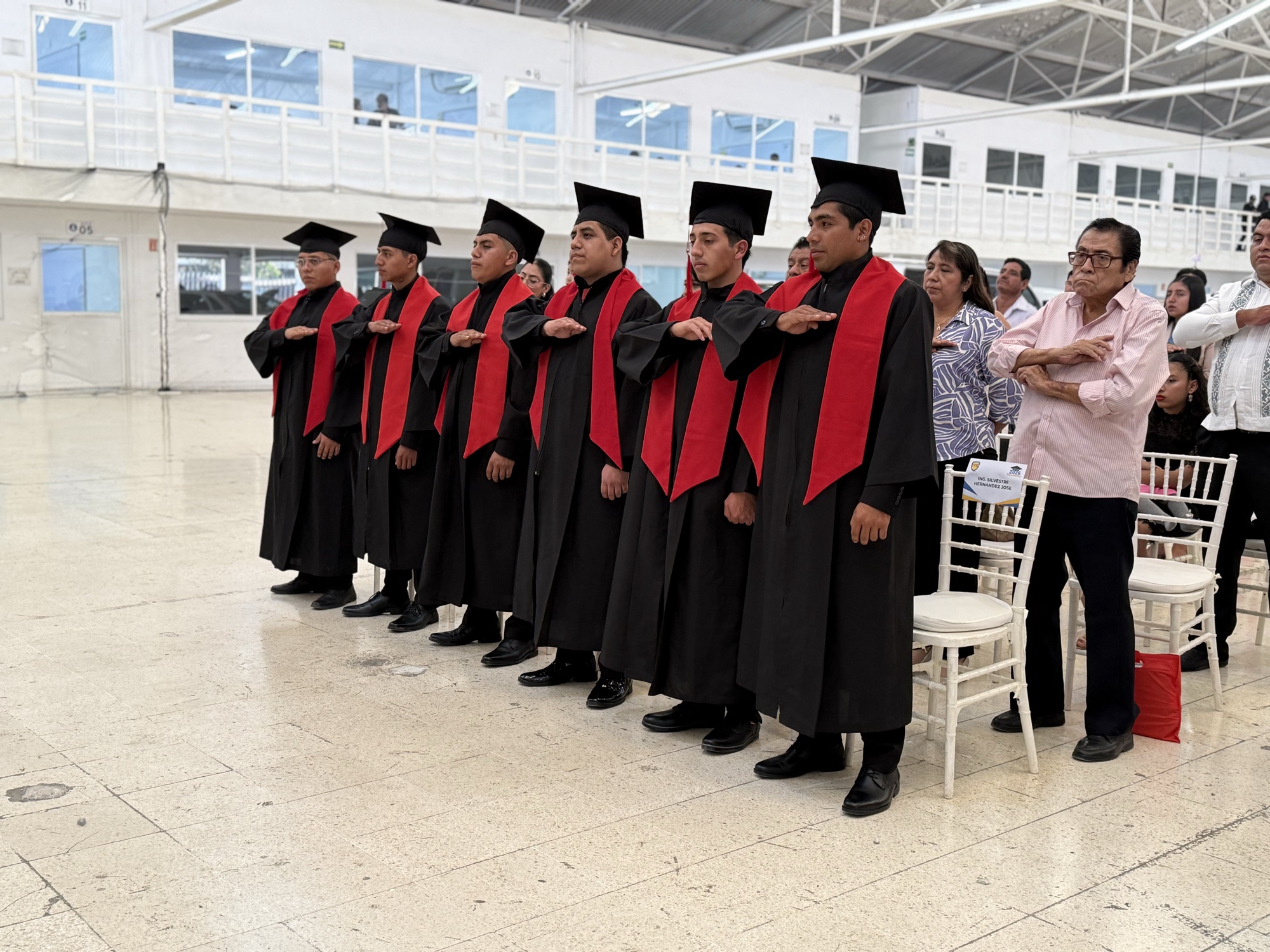 Egresados de Universidad ITE participando en el acto de graduación