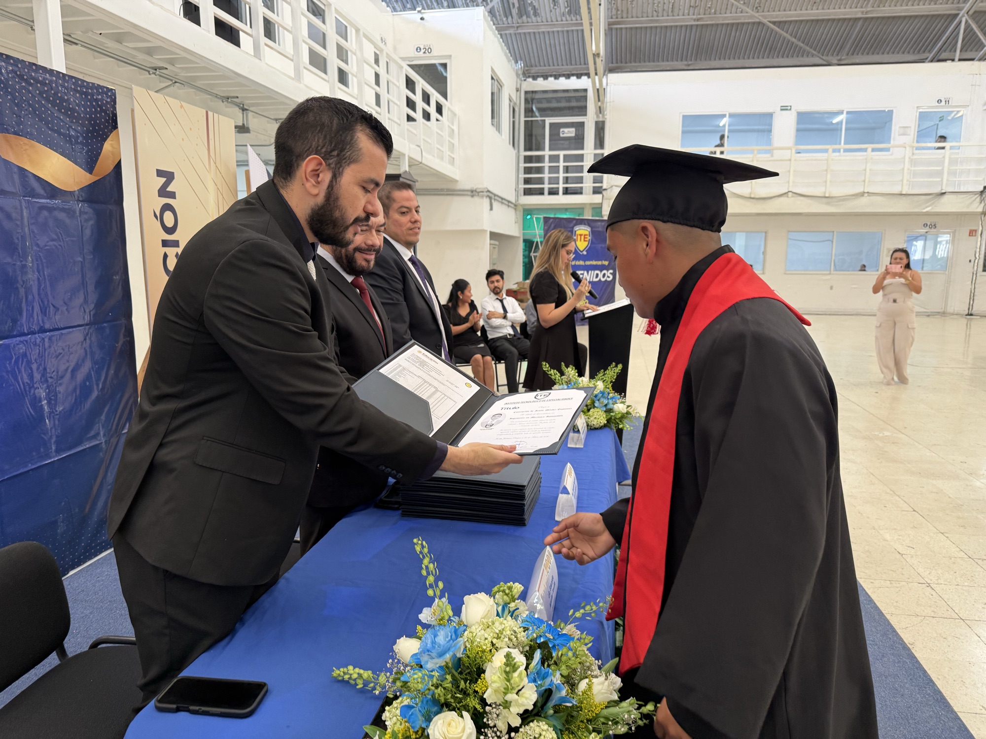 Autoridades entregando documentos a un egresado de Universidad ITE
