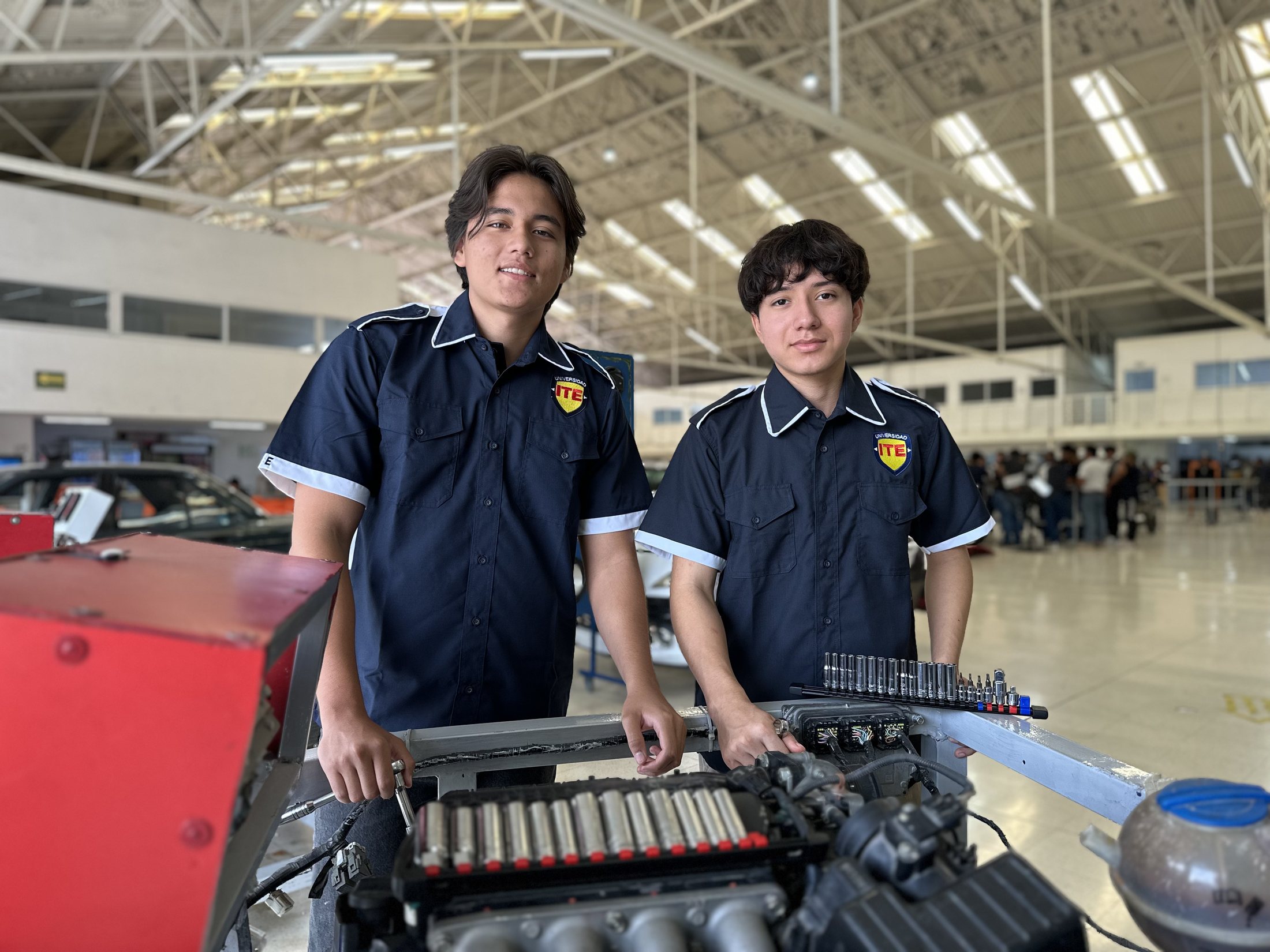 Estudiantes de Universidad ITE junto a un motor de prácticas