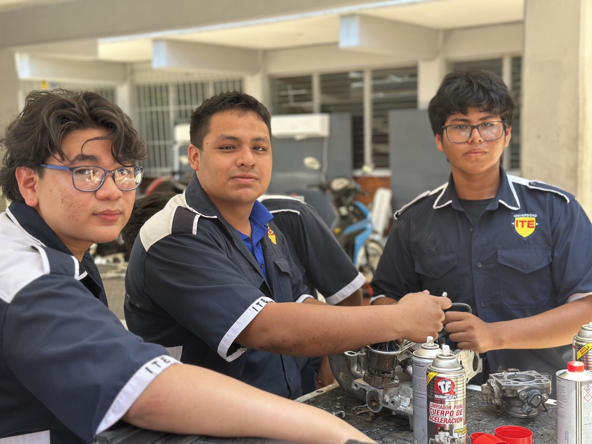 Estudiantes de Universidad ITE reunidos en el taller automotriz