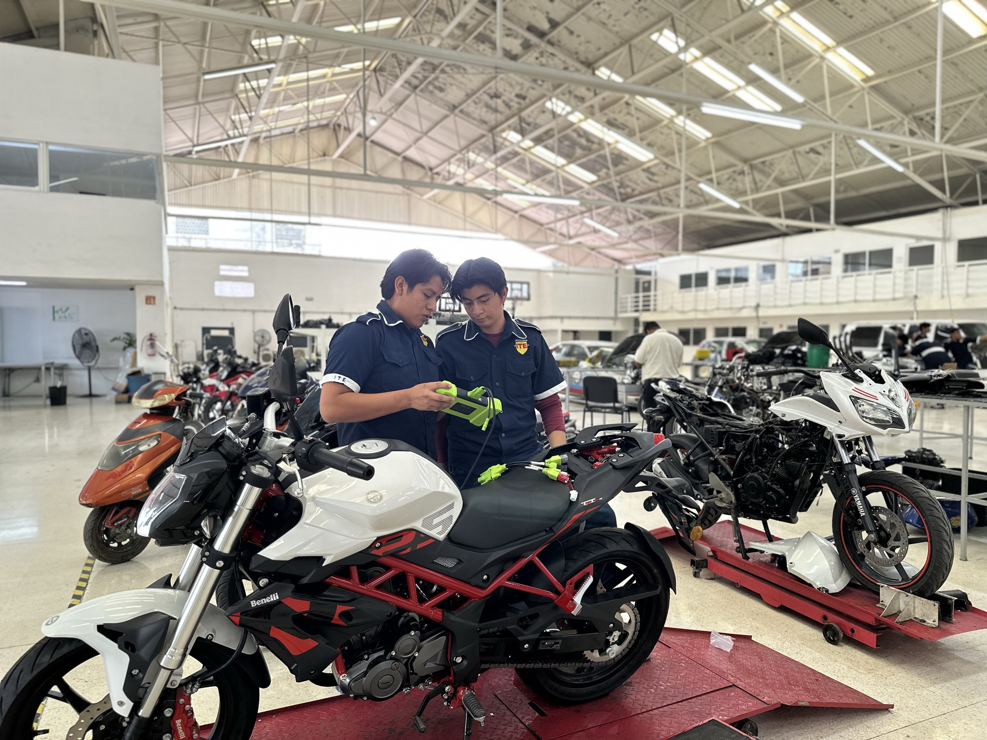 Estudiantes diagnosticando una motocicleta en el taller de Universidad ITE