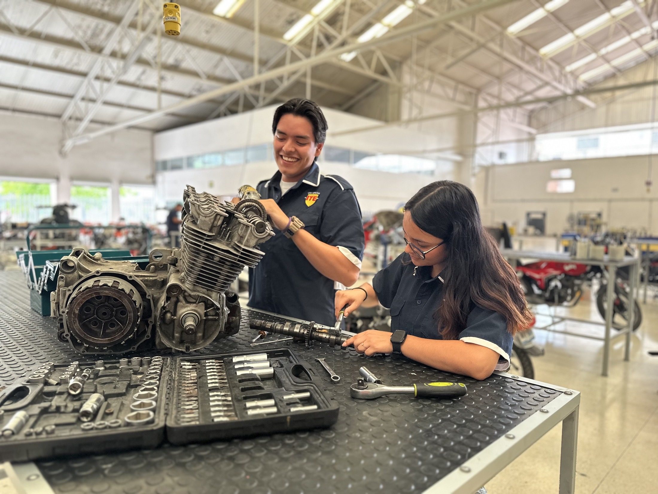 Estudiantes trabajando con componentes de un motor